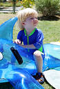 Young boy or child sitting on inflatable dolphin by swimming pool