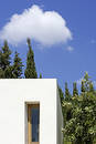 New, white building with trees and blue sky