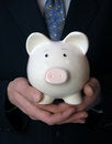 Businessman holding a piggy bank