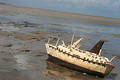 Wood carving of a ship stranded on the beach