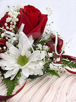 Rose rosse e fiori in cima torta di nozze.