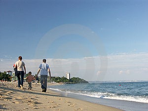 Otec a mama s ich malé dieťa prechádzky popri pobreží.