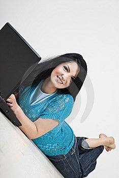 Krásná bruneta žena ležící na dřevěné podlaze relaxační a prohlížení internetu na notebooku, viz více Lidí na gauči nebo dřevěné podlahy.