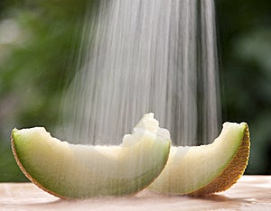 Fette di melone sotto l'acqua corrente.