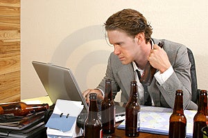 Obchodné muž na stole prázdnych fliaš piva.