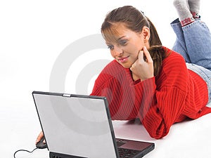 Mladé krásné ženy na bílém gauči relaxační a pomocí přenosného počítače.