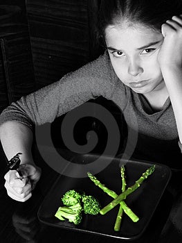 Mladá dívka hledá vztek při pomyšlení, že zelenina na večeři selektivní Barva.