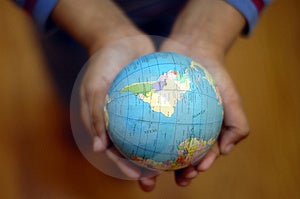 Dítě drží zeměkoule v ruce.