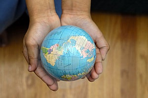 Dítě drží zeměkoule v ruce.