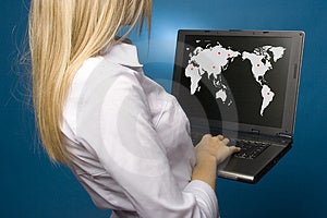 Žena drží notebook s mapa sveta na obrazovke.