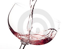 El vino tinto para el flujo en un vaso.