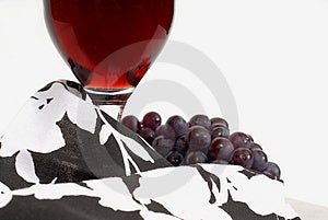 Un punto de vista de una copa de vino con la uva y el vino y la servilleta.