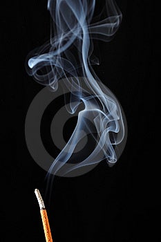 Brucia incenso con il fumo su sfondo nero.