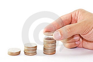 Stack money and a hand putting a coin Stack money and a hand putting a coin