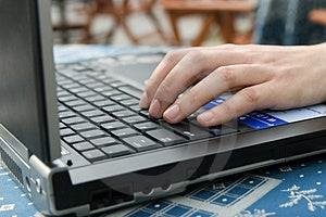 Žena v kavárně pracuje na notebooku.