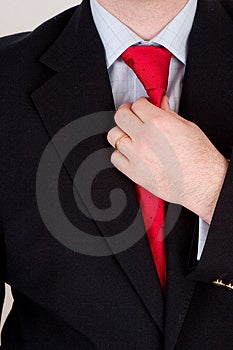 Obchodné muž v modrom obleku, rovnanie jeho červenú kravatu.