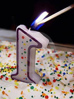 Número uno vela sobre el pastel vistoso aspersores ser se ilumina fósforo.