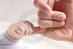 Piccolo bambino e la mano a papà dito.