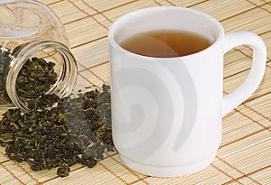 Tasse Tee und Teeblätter auf Bambus-hintergrund.