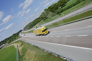 Veľké žlté vozidlo prekročenie rýchlosti na diaľnici nastaviť v krajine, na strane okolie, a nie známky.