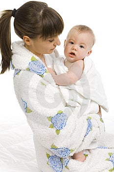 Giovane madre in accappatoio holding bambino in un asciugamano.