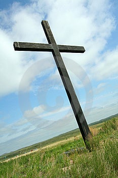 Černý kříž stojí v stepi.