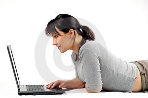 Atractivo una mujer acostada en blanco computadora portátil.