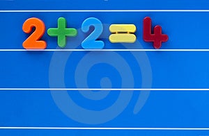 Una semplice somma, da un bambino giocattolo numero di set, posto su un blu, foderato in background.