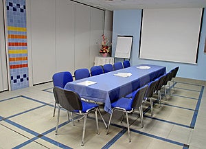 Prázdné konferenční místnost s promítacím plátnem.