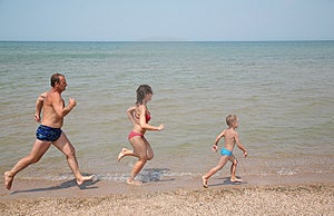 Nonno figlia e nipote di correre per la spiaggia.