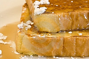 Francúzsky toast na bielom plechu s práškovým cukrom a javorový sirup.