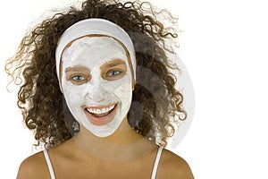 Giovane donna felice con il bianco maschera purificante.