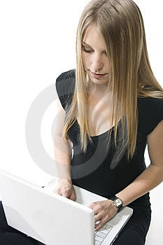 Žena sedí na podlahe s bielym prenosný počítač.