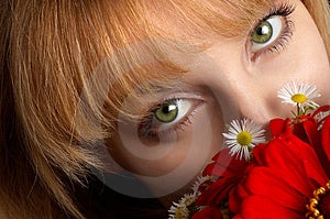 Belle ragazze con gli occhi verdi e un bouquet di fiori rossi.