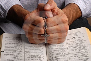Sacra bibbia aperta con una croce in mano.