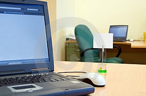 Prázdný open-plan office s prázdné upomínku na stůl pomocí přenosného počítače.