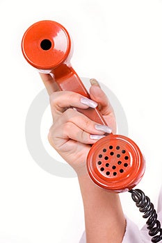 Womans ruke drží červený telefón.