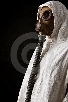 Persona in maschera a gas su sfondo scuro.