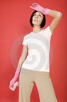 Giovane donna in rosa guanti di gomma tiene in mano guanto di spugna.