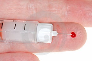 Prst s krví drop a inzulínu vstřikovače.