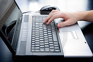 Masculino mano emprendedor entrar sobre el computadora portátil teclado.