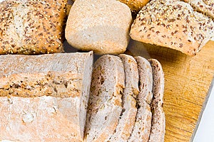 Fette di pane con focaccine di pane su un tagliere di legno.