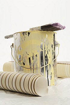 Štětcem namočeným do fialové barvy na vršek plechovky žluté barvy s dvěma zdi vzorky papíru na obou stranách.