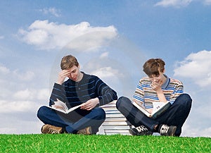 Dvoch študentov s knihou na pozadí modrej oblohy.