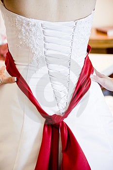 Svadobné šaty s červenou šerpou.