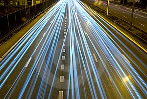 Autostrada di notte con il movimento dei fari dell'auto.