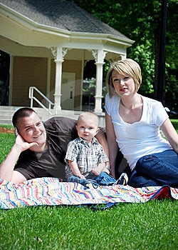 Una famiglia felice sdraiato su un pic-nic tappeto di erba.