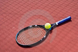 Un conjunto compuesto por tenis verde esfera metido sobre el tenis la corte sombra.