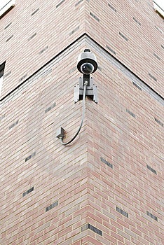 Namontované na rohu, tehlovej steny, bublina-glassoverhead bezpečnostné kamery sleduje jeho okolí.