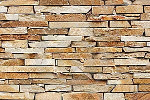 Irregolare muro di mattoni con varie tonalità e forme di mattoni.